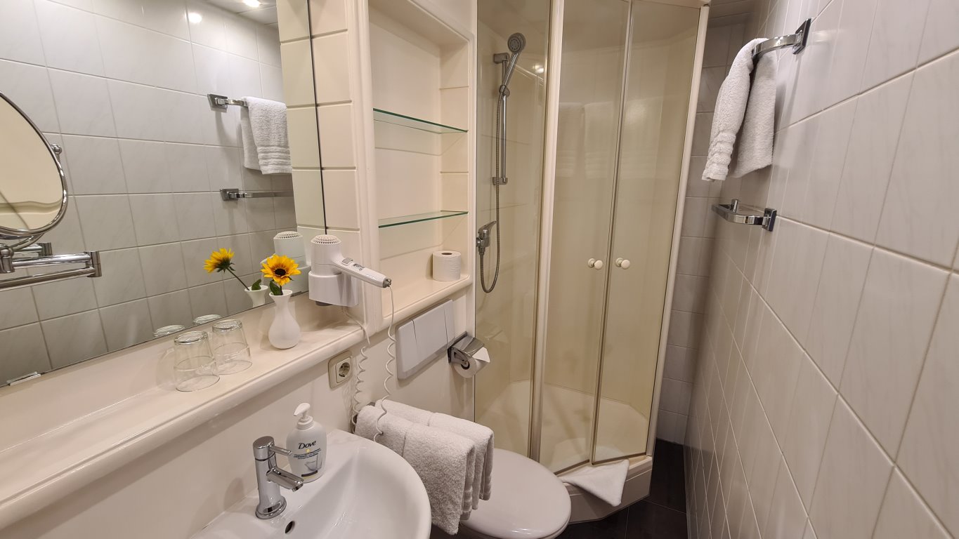 Das Badezimmer mit Dusche, Waschbecken und WC der Ferienwohnung 4