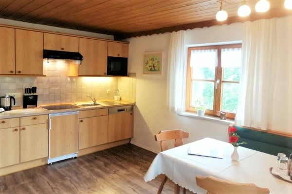 Großer Esstisch mit Eckbank und Küchenzeile in der Ferienwohnung 2 im Haus Alpenblick